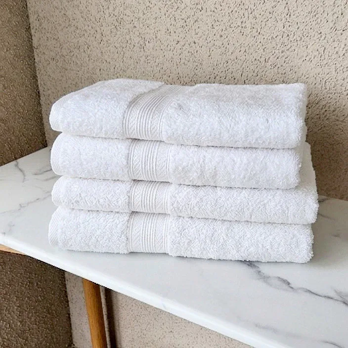 Pila de toallas blancas de algodón sobre una mesa de mármol
