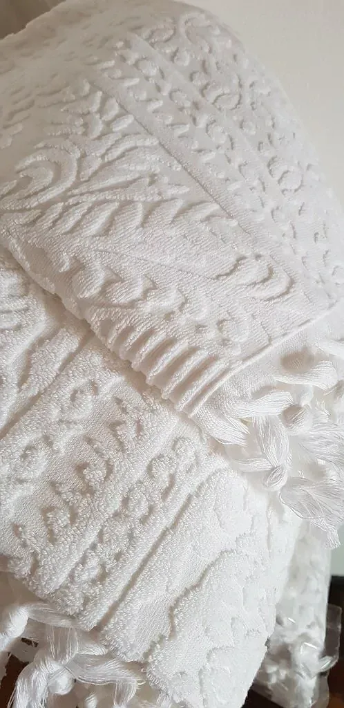 Detalle de toalla blanca de algodón con relieve y flecos